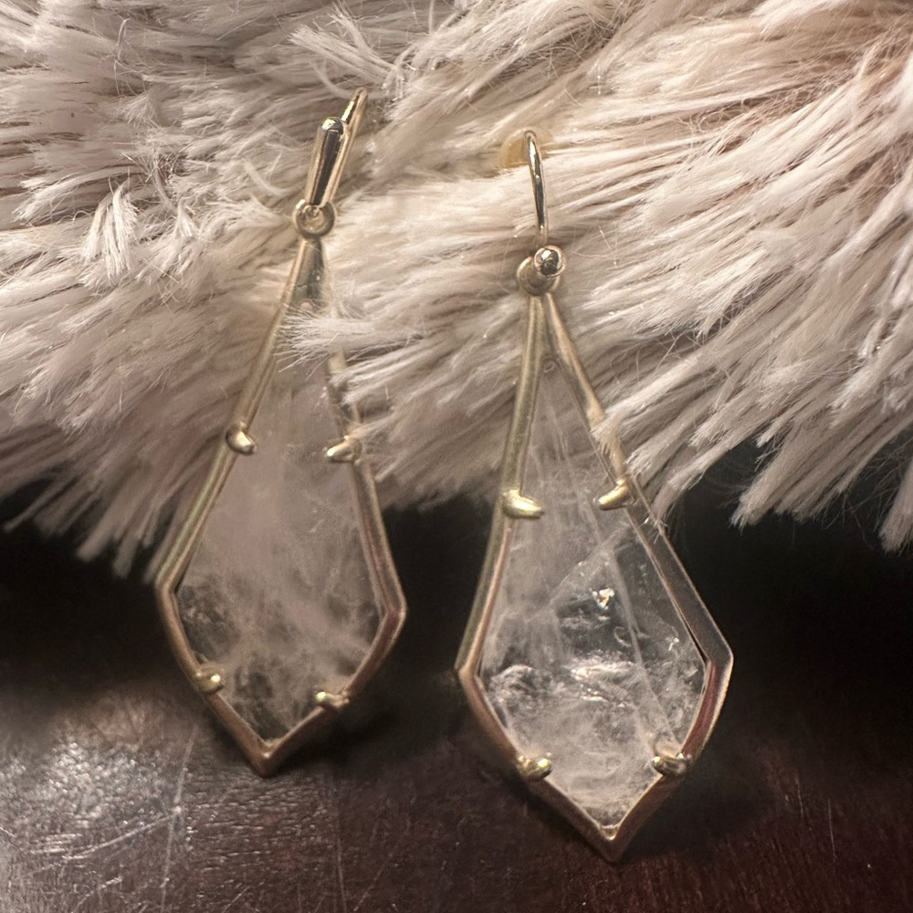 Kendra Scott gold drop earrings.